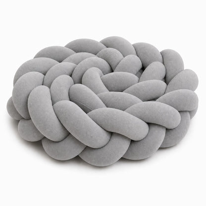 Tour de lit tressé gris pour bébé dans un lit à barreaux.