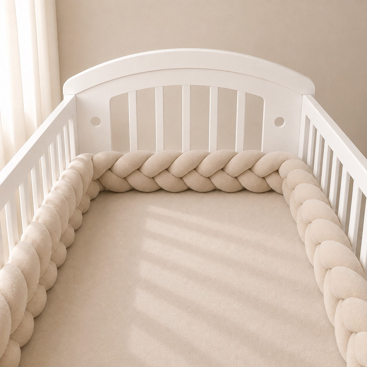 Tour de lit tressé beige installé dans un lit bébé en bois